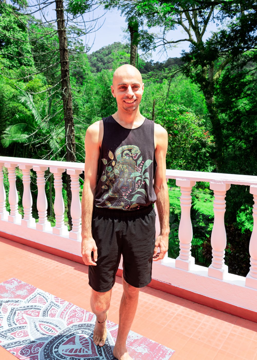 Portrait of Dominik Wagner smiling on a balcony surrounded by greenery